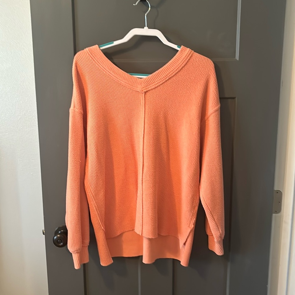 Aerie v-neck/off the shoulder oversized sweater in a peach color.